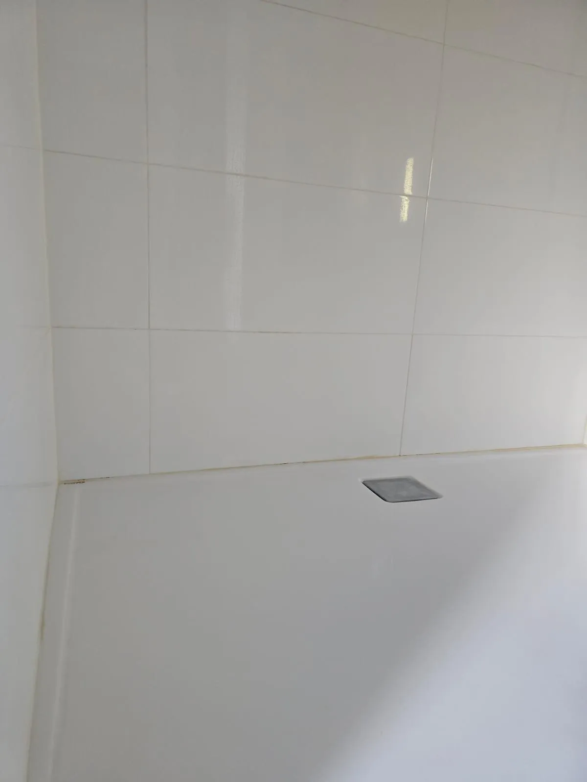Alte, verfärbte Silikonfuge zur Wand in einer Dusche, Vorher